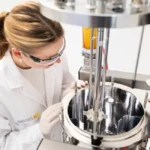 Technician inspecting the open vessel of an Infors Techfors-S 2 bioreactor
